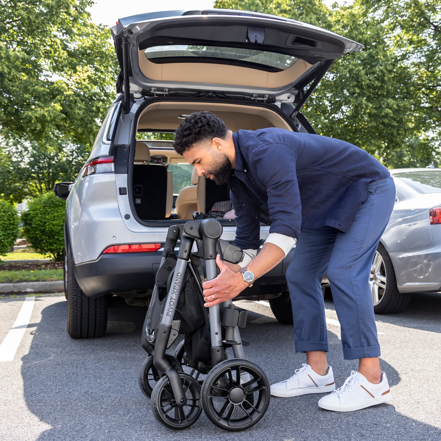 Evenflo Pivot Xpand Modular Stroller folded and being placed in trunk