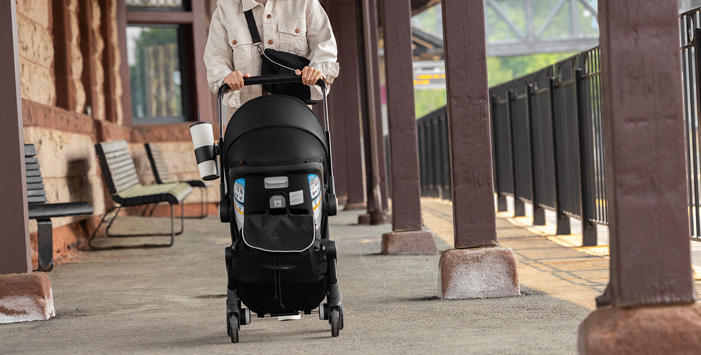Person pushing Evenflo DualRide stroller at a train station