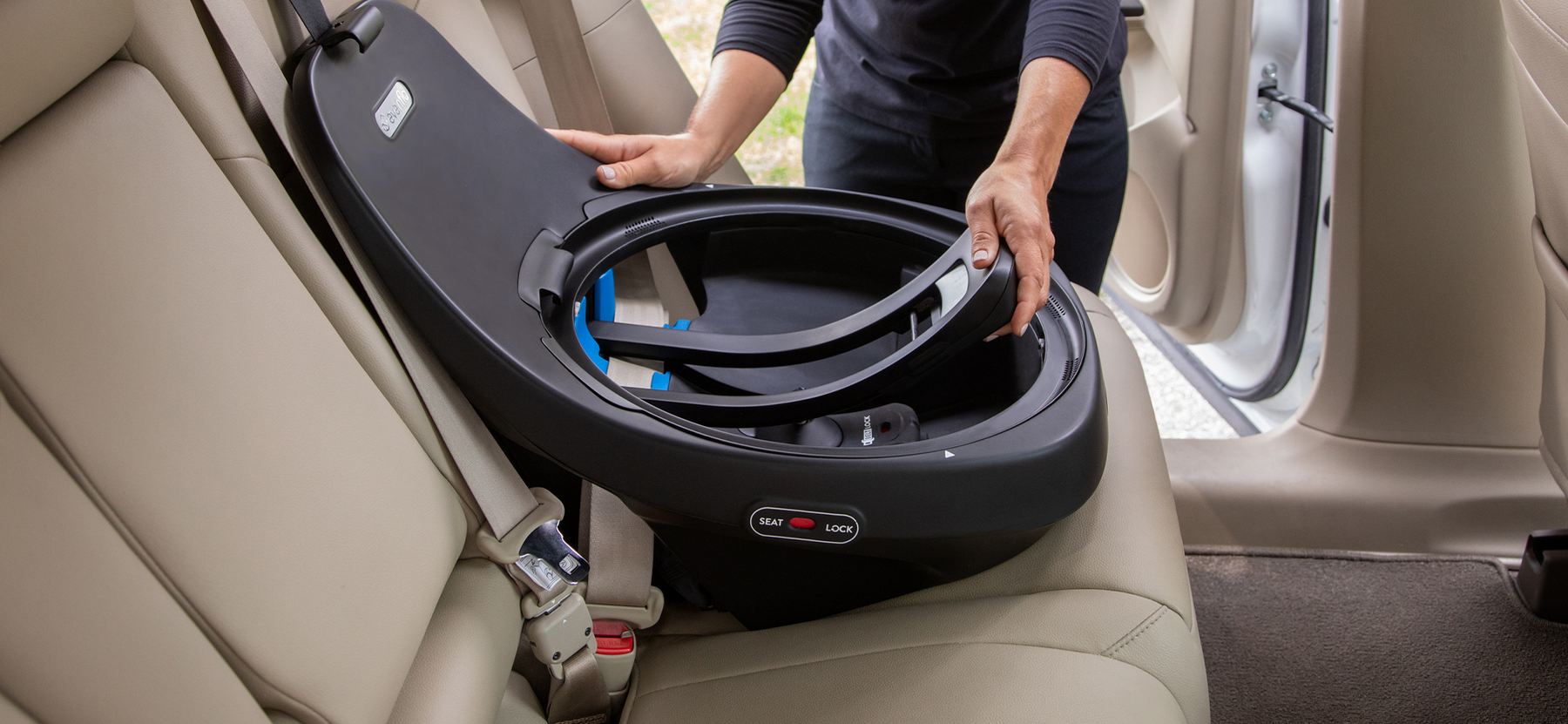 Image of hand holding car seat base in the car showing the seat lock feature.